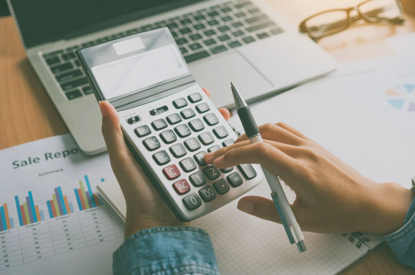 Person inputting information on a calculator Person inputting information on a calculator